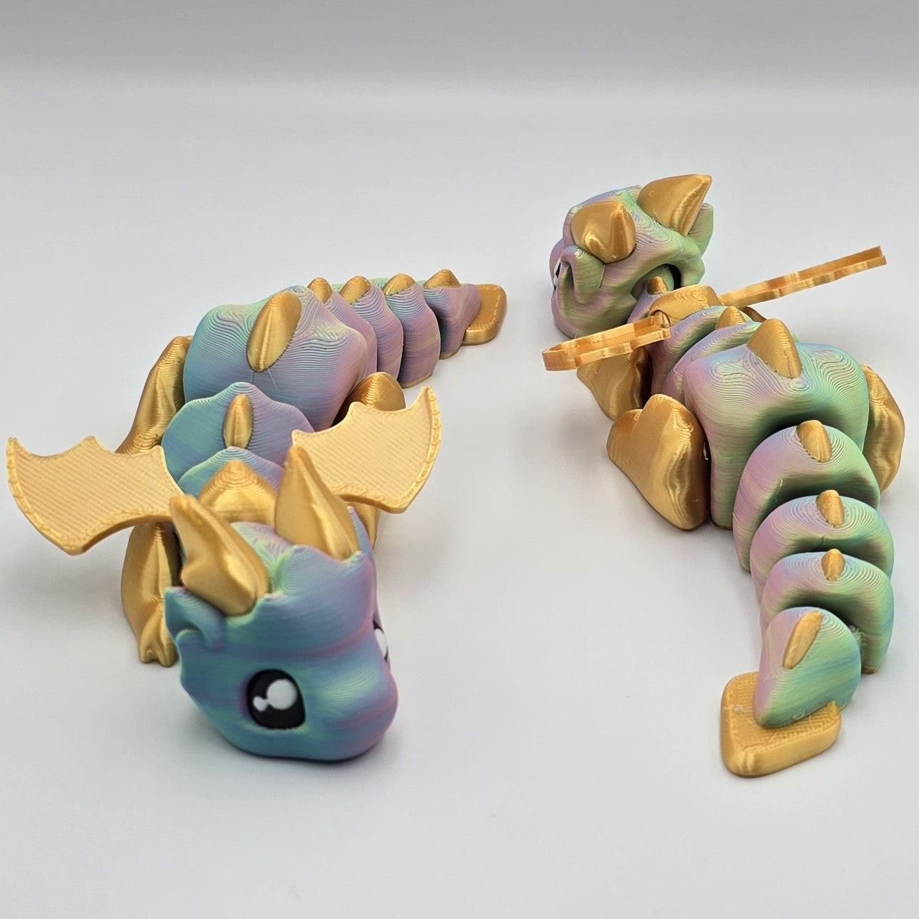 Articulated Baby Dragon – Rainbow & Gold  design by Layers In Green