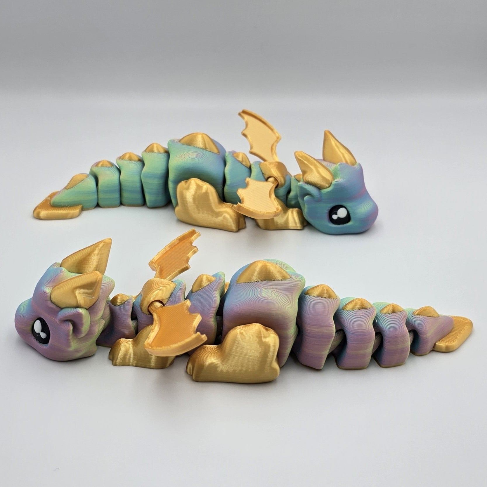 Articulated Baby Dragon – Rainbow & Gold  design by Layers In Green